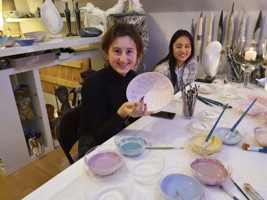 Kinder bemalen Keramik im Atelier